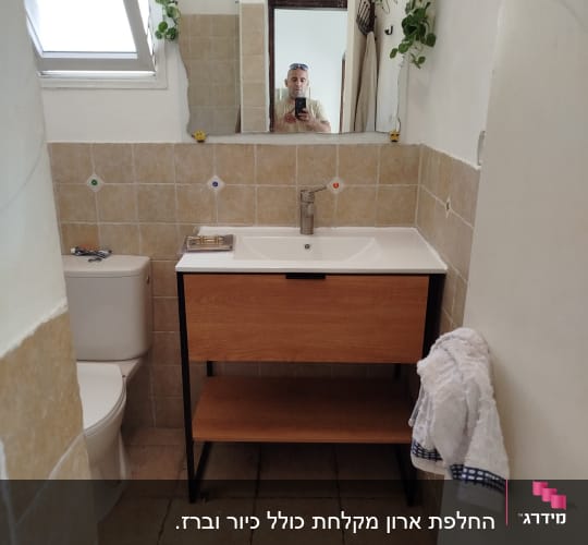כיור ואסלה בחדר אמבטיה עם מראה